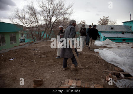 Afghanischen Stadtarbeiter legen Ziegel auf dem Dach der Kinderstation in Ghazni Stadt Krankenhaus Ghazni District, Provinz Ghazni, Afghanistan, 23. April 2013. Am 8. März 2013 beschädigte ein Brand der Kinderstation. Die Mittel für die Renovierung der Kinderstation wurden vom Direktor des Ministry of Health, Zya Gul Asfandi durch die Stadt Nejat sozialen Rat von Ghazni angefordert. Der Sozialrat Nejat ist eine Friedensgruppe, deren Ziel es ist, Unterdrückung, Korruption und Ungerechtigkeit in Abstimmung mit der afghanischen Regierung zu beseitigen.  (US Armee-Foto von Spc. Jessica Reyna DeBooy/freigegeben) Naswan Shaher Kohna Schule Stockfoto