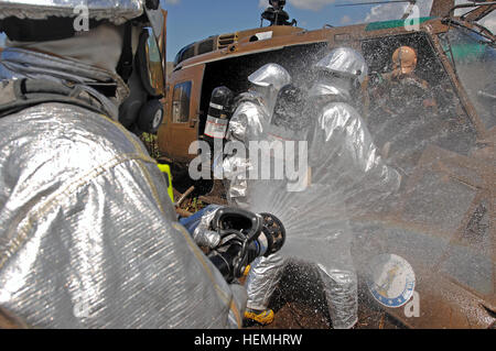 Eine Bürger-Soldaten der Nationalgarde Puerto Rico 215. Fire Fighting Team, 130. Pionierbataillon 101. Truppe Befehl sprüht Wasser an einem UH-1 Huey Hubschrauber, wie seine Kameraden darauf vorbereiten, einen simulierten Verwundeten Piloten während eines simulierten Absturz Website Trainings im Camp Santiago gemeinsame Manöver Training Center am 1. Mai 2013 zu extrahieren. Die Feuerwehrleute ausgebildet zusammen mit Mitgliedern der Feuerwehr von Puerto Rico, wie sie ihre Fähigkeiten in einem gemeinsamen Training besser auf die bevorstehende Wildfire-Saison vorzubereiten geschliffen. (US Armee-Foto von Staff Sgt. Joseph Rivera Rebolledo, Public Affairs Specialist, Puerto Rico N Stockfoto