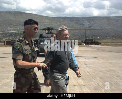 Autoguider Xavier de Lambert (französische Armee), IFOR COMDIV MND-SE (Division Commander multinationale Division Südost), geht über den Asphalt mit Honorable Walter B. Slocombe, unter Minister fuer Verteidigung (Politik), am Flughafen in Mostar, Bosnien-Herzegowina, vor einem unbekannten französischen Soldaten und einem geparkten Hubschrauber UH-60A/L.  Mr. Slocombe ist bei einem zweitägigen Besuch in Bosnien und Herzegowina, IFOR Personal- und verschiedenen bosnischen bürgerlichen Führer zu treffen. Gen Xavier de Lambert DD-SD-00-00145 Stockfoto