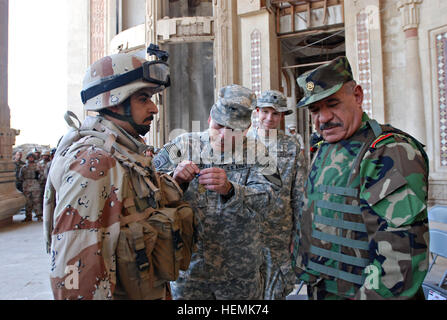 Major General John Campbell, zweite von links, Multi-National Division-Bagdad stellvertretender Kommandeur für Manöver und gen Abud Qanbar, Iraks Oberste militärische Befehlshaber, pin ein Army Achievement Medal auf einen Soldaten aus A Co, 1. Bataillon, 1. Gebäudezuständen, 11. irakische Armee-Division, geholfen seine amerikanischen Kollegen finden eine tief begraben improvisierten Sprengkörpern potenziell katastrophale Verluste abzuwenden, während einer Zeremonie im Combat Outpost Apache im Stadtteil Adhamiyah , Bagdad, 23.August. Irakische Soldaten geehrt für IED Entdeckung 54614 Stockfoto