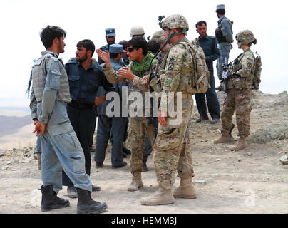 US Army Captain Daniel Maxfield der Executive Officer Blue 0 Security Force Advisory Team und afghanischen Sprache Dolmetscher sowohl in Forward Operation Base Rushmore stationiert zugewiesen, Provinz Paktika diskutieren Betrieb Omna mit einem Mitglied der afghanischen Uniform Polizei stationiert im Stadtteil Omna, 6. Juli 2013. Die ANSF ausgeführt ihre Mission schnell mit begrenzten Fachberatung, verlassen Koalitionstruppen wenig zu tun, sondern folgen Sie entlang zu Enabler unterstützen bei Bedarf. (Foto von US Armee Sgt. Mark A. Moore II - 2/10 Kräfte Hilfe Sicherheitsbrigade) ANSF sichern Omna 130706-A-XX999-001 Stockfoto