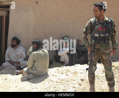 Eine afghanische Nationalarmee Commando mit 1. Firma, 3. spezielle Operationen Kandak, wacht über Dorfbewohner während einer Clearing-Operation in Shah Wali Kot district, Provinz Kandahar, Afghanistan, 6. Juli 2013. Die Commandos führte die Operation um Aufständische Bewegungsfreiheit im Bereich verweigern und für das weitere Fortschreiten der Kommandos ermöglichen, unabhängige Operationen durchzuführen. (Foto: U.S. Army Pfc. Joshua Mckinney / veröffentlicht) Clearing-Betrieb 130706-A-LX590-163 Stockfoto