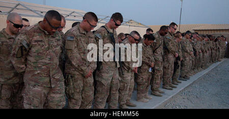 Zivile Auftragnehmer und Service-Mitglieder stehen und beten, das Leben der US-Army Spc. Hilda Clayton auf Forward Operating Base Gamberi, Afghanistan, 8. Juli 2013 zu Ehren.  SPC. Clayton starb beim Fotografieren der Afghan National Army Soldaten, wie sie eine live-Feuer-Übung, 2. Juli 2013 durchgeführt. Eine Mörtel Waffensystem ist fehlgeschlagen, wodurch eine katastrophale Explosion während des Vorfalls vier ANA Soldaten, die Teilnahme an der Schulung starb. Clayton, von Augusta, Georgia, wurde vorwärts in Afghanistan eingesetzt, als die Bekämpfung Kamera-Anlage für die 4th Brigade Combat Team, 1. Kavallerie-Division ' t Stockfoto