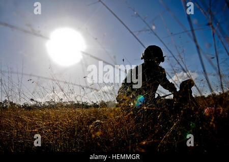 US Army Staff Sgt Daniel Liss, mit Comanche Unternehmen, 1. Bataillon, 501. Infanterie-Regiment, 4th Infantry Brigade Combat Team (Airborne), 25. Infanterie-Division, hagelnd von McHenry, Ill., sichert seine Ausrüstung nach Fallschirmspringen in Shoalwater Bay Trainingsbereich, Australien, 20. Juli 2013, im Rahmen der Operation Talisman Saber 2013. Talisman Saber 2013 bietet effektive und intensive training, um sicherzustellen, dass die amerikanischen und australischen Truppen in der Lage, interoperable und kurzfristig einsetzbar sind. (Foto: US-Armee Sgt. Eric James Estrada /Released) Spartan Fallschirmjäger am Talisman Saber 2013 130719- Stockfoto