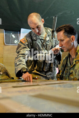 US Army Captain Ross Low, Schlacht Kapitän für Spartan Task Force, 4th Infantry Brigade Combat Team (Airborne), 25. Infanterie-Division, bietet eine kurze Operationen für australische Armee Generalmajor Stuart Smith, des Kommandierenden Generals der 1. Division/Deployable gemeinsamen Kraft-zentrale im Schlachtfeld Hauptquartier der Brigade während Talisman Saber 2013 bei den Trainingsbereich Shoalwater Bay in Queensland, Australien. Talisman Saber ist eine Biennale Übung, die USA und Australien Kampfbereitschaft und Interoperabilität durch kombinierte Ausbildung verbessert. (US Army Foto von Staff Sgt Jeffrey Smith/R Stockfoto