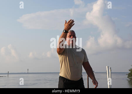 US Army Staff Sgt Mark Barnett, zugeordnet der 982nd Combat Camera Company (Airborne), Ostpunkt, Ga., kommuniziert mit einem anderen Soldaten, ein Boot in der Bucht für Helocast Betriebstraining aus einem UH-60 Black Hawk-Hubschrauber in Tampa Bay, Florida, 27. Juli 2013 zu platzieren. Soldaten mit 982nd Combat Camera Company (Airborne) stehen in Booten zu Kameraden aus dem Wasser zu erholen. (US Armee-Foto von Spc. Tracy McKithern/freigegeben) Helocast Operationen 130727-A-LC197-099 Stockfoto