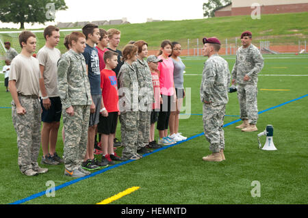 Sgt Danny J. Barnett, Infanterist zugewiesen, die 1. Staffel, 73. Kavallerie-Regiment, 2nd Brigade Combat Team, 82nd Airborne Division Slips Servicemembers Kinder auf Drill und Zeremonie am Towle Stadion am Fort Bragg, N.C., 15. August 2013. Fallschirmjäger und ihre Familien beteiligt das Geschwader ersten Kindertag, eine Veranstaltung organisiert, um moralisch zu erhöhen und starke Bindungen zwischen den Servicemembers, ihre Familien und die Einheit zu bauen. Graue Falken kick-off ersten Kindertag 130815-A-DP764-010 Stockfoto