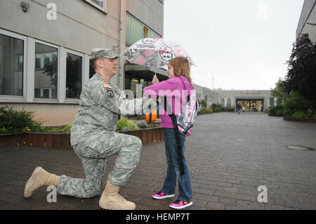 Staff Sgt Michael Allen, eine militärische Gebrauchshund Liaison mit dem 95. Military Police Company, 18. MP-Brigade, 21. Theater Sustainment Command und gebürtig aus Louisville, Kentucky, fixiert seine Tochter Aveleyn Jacke, an der Middle School in Sembach 26. August. Soldaten der US-Armee europaweit ihre Kinder abgesetzt für ihren ersten Schultag. (Foto von Spc. Iesha Howard, 21. TSC Public Affairs) DoDDS Schüler kommen für den ersten Schultag 130826-A-LN304-001 Stockfoto