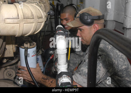 SPC. Miguel S. Rodriguez, gebürtig in Tampa Florida und ein Wasserfahrzeug mit der Armee Watercraft Gesellschaft (provisorisch), 371st Sustainment Brigade und Spc. Kevin L. Terre, ein Lacey Wash Native und ein Wasserfahrzeug Ingenieur auch mit der Armee Watercraft Gesellschaft (provisorisch), Ingenieur 371. Sus. BDE., wechseln Sie das Öl von einer der Motoren auf der United States Army Wasserfahrzeug Schiff, Churubusco, Landing Craft Utility 2013 auf See am 27. August 2013.  Die Crew der LCU-2013 ist zur Unterstützung der Operation Enduring Freedom im Marinestützpunkt Kuwait, Kuwait im Einsatz. Ein Blick unter Deck, Ingenieure Armee Wasserfahrzeug sh Stockfoto