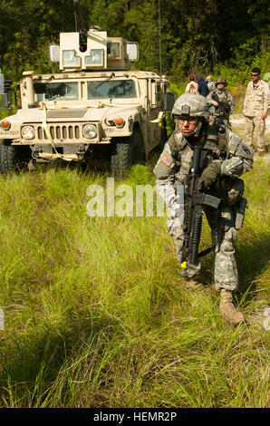 Georgien GARNISON TRAINING CENTER, Fort Stewart, Georgia, 11. September 2013 – Sgt. Angela Martin, ein Militär-Polizisten mit Statesboro Sitz und Sitz Ablösung, 48. Brigade Special Troops Battalion wechselt zur Deckung zur Aufrechterhaltung der Sicherheit für eingehende Mediziner während einer Leistungsbewertung exportierbar Combat Training Fähigkeit (XCTC)-Übung zu finden. Georgia National Guard 48. Infantry Brigade Combat Team beherbergt das XCTC-Programm, um Soldaten ein Erlebnis ähnlich Kampfeinsätze im Ausland zur Verfügung zu stellen. XCTC ist ein Bataillon Feld-Training Instrument Compan zertifizieren Stockfoto