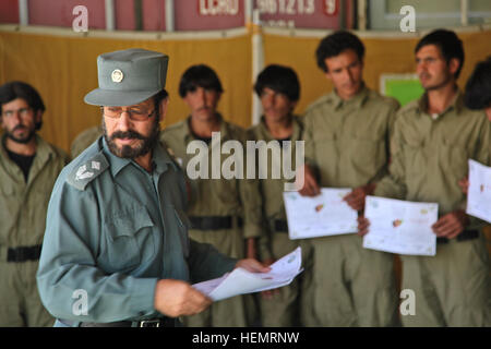 Major Akbar der Provincial Training Center-Kommandant, übergibt Zertifikate der Fertigstellung afghanischen lokalen Polizei (ALP) Auszubildenden während Abschlusstag, Ghazni District, Provinz Ghazni, Afghanistan, 26. September 2013. 57 ALP Auszubildenden vorbereitet Abschlusstag in Ghaznis provinziellen Trainingscenter nach einer umfangreichen drei afghanischen Führung ALP Wochenprogramm welche Abdeckungen berufliche Entwicklung, Medizintechnik, kleine Einheit Taktik und Waffenfertigkeiten.  (US Armee-Foto von Spc. Jessica Reyna DeBooy/freigegeben) Vorbereitung für die Graduierung 130926-A-SL739-075 Stockfoto