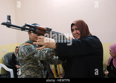 071010-A-5406P-013. JPG – East Los Angeles, Kalifornien-Native 2nd Lt. Lauren Cabral, ein Pflege-Offizier mit der 3. Infanterie-Division 3rd Squadron, 7. Kavallerie-Regiment, befestigt die 2. BCT, 82. US-Luftlandedivision, hilft eine irakische Frau während einer Waffen Einarbeitung Klasse Okt. 10 komfortabel mit dem automatischen Gewehr AK-47 zu erhalten, die Bestandteil der Ausbildung für die erste Gruppe von weiblichen irakischen Sicherheit Freiwilligen in Bagdads Adhamiyah Nachbarschaft war. (US Army Foto von Sgt. Mike Pryor, 2. BCT, 82nd Airborne Division Public Affairs) Irakische Frau mit Ziel Stockfoto