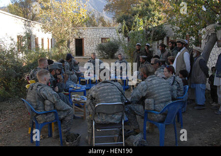 Soldaten von bestimmt Company, 2nd Battalion (Airborne), 503. Infanterieregiment, Sub Narang Governors und ältesten setzte sich für Tee und eine Schlange, nachdem sie vorbei, alle Spenden, die alle Mädchenschule im Stadtteil Narang Konar Provinz, Afghanistan, Dez. 4. Die Lieferungen werden von der Schule für die Kinder während des Schuljahres (US Armee Foto/Sgt. Johnny Aragon) Narang Bezirk Operationen 70672 verwendet werden Stockfoto