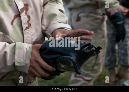 US Army Pvt. Pablo Chang, 55. Signal Company (Combat Camera) zugewiesen bereitet sich auf seine Schutzmaske in Fort Meade, Maryland, 17. Oktober 2013 don. Die Soldaten waren für eine Übung in Reaktion auf einen Angriff mit biologischen Angriff vorzubereiten.  (US Armee-Foto von Sgt. Kristina Truluck/freigegeben) Armee Krieger Ausbildung 131017-A-VB845-084 Stockfoto