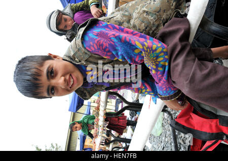 Ein kleiner Junge fröhlich für die Kamera lächelt, als er hilft eingerichtet das die afghanischen Frauen Basar, neue Compound Kabul, Afghanistan, 23. Oktober 2013. Die afghanischen Frauen und Kinder kommen zu NKC hausbacken Handwerk und vieles mehr zu verkaufen. Der Basar ist eine Chance für die Frauen und Kinder zur Unterstützung ihrer Familien durch den Verkauf von afghanischen Souvenirs. (Fotos: US-Armee Sgt. 1. Klasse Timothy Rasen, 1. Theater Sustainment Command Public Affairs/freigegeben) Chitter-Geschwätz von kleinen Kindern erfüllen die Luft als neue Kabul Compound, afghanische Frauen %%% E2 %%% 80 %%% 99s Basar erwacht zum Leben 131023-A-WQ129 - Stockfoto