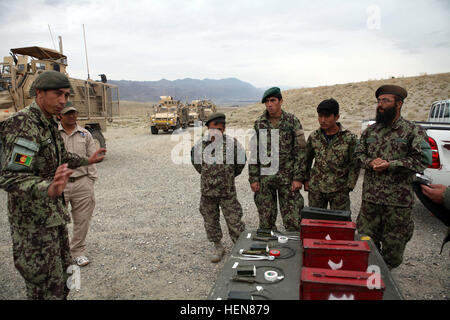 Ein hochrangiger Offizier mit der afghanischen Nationalarmee 201. Corps Slips seine Soldaten vor Beginn eines Trainings im Bereich Abbruch auf Forward Operating Base Gamberi, Provinz Laghman, 5. November 2013. Der Abriss ist der ANA-Website für eine Explosive Gefahr Reduktionspfad. (US Army Foto von Spc. Ryan D. Grün/freigegeben) Afghanische Soldaten führen auch Schulungen bei den Sprengstoff Hazard Reduktion Kurs 131105-A-YW808-123 Stockfoto