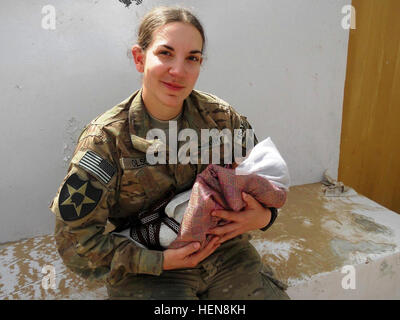 SPC. Heidi Olson hält afghanischen Kleinkind während in Afghanistan in diesem undatierten Foto. Olson war ihr distinguished Service von Präsident Barack Obama während einer Zeremonie im Weißen Haus, 4. Juli 2013, durch ihre selbstlosen Handlungen in Afghanistan im Zuge einer improvisierten Sprengsatz-Attacke im Mai 2012 anerkannt. Olson "musste bestellt werden, zu stoppen und Behandlung für sich selbst als Medevac-Flugzeuge ankamen," sagte der Präsident. "Und für ihren Mut wurde sie Bronze Star ausgezeichnet." (Höflichkeit Foto) 3-2 SBCT Pläne für die Bedürfnisse der "Schwestern in Armen" durch mentorshi Stockfoto