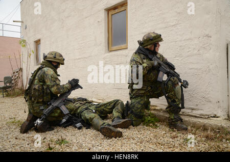 Ein Soldat der Armee der Tschechischen Republik 72. mechanisierte Brigade führt erste-Hilfe auf ein fiktiv verwundeter Soldat, während ein anderer Soldat Sicherheit während des Trainings kombiniert Entschlossenheit bei der Joint Multinational Readiness Center in Hohenfels, Deutschland, 17. November 2013 bietet.  Die Absicht der Übung ist, zu trainieren und Vorbereiten der U.S. multinationalen Brigaden zusammenarbeiten, mit mehreren Partnernationen gegen eine komplexe Bedrohung führte. (US Armee-Foto von Spc. Wayne Becton/freigegeben) Tschechische Republik Soldat mit der 72. mechanisierte Brigade führt erste Hilfe auf einen simulierten verwundeten Soldaten, während ein anderer Soldat pro Stockfoto