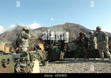 US Army Staff Sgt. Trenton R. Farris, links, 1. Abteilungsleiter der 2. Zug, Alpha-Batterie, 4. Bataillon, 319th Airborne Field Artillery Regiment, Stecker seine Ohren wie ein Afghan National Army Soldat Field Artillery Company, 4. Bataillon, 3. Brigade zieht das Verbindungsmittel beim gemeinsamen live-Feuer-Training am M-198-Haubitze auf Forward Operating Base Kalagush in Nuristan Provinz, Afghanistan zugewiesen , 28. Januar 2008. (Foto: U.S. Army Spc. Gregory Argentieri) (Freigegeben) US-Soldaten Abdeckung Ohren während Soldaten der afghanischen Nationalarmee M-198 Haubitze feuert Stockfoto