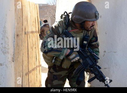 Ein Afghan National Army Special Forces Soldaten bewegt sich auf ein anderes Haus während einer Clearing-Operation in Mohammad Ghaws Dorf 16. Dezember 2013, im Ab Band District, Provinz Ghazni, Afghanistan. Die Sicherheitskräfte entdeckten viele improvisierte explosive Vorrichtungen und Waffen Caches während des Betriebs. Sie fanden mehrere Pfund hausgemachte Sprengstoff, Handgranaten, ca. 200 Schuss von AK-47 Angriff Gewehrmunition und medizinische Versorgung. (Foto: US-Armee Sgt. Jared Gehmann) ANASF, ALP reduzieren Waffen, explosive Caches 131216-A-ZR634-120 Stockfoto