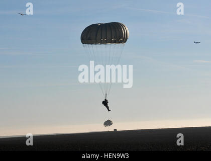 Ein Fallschirmjäger aus der 5. Quartiermeister Detachment (Airborne), 21. Theater Sustainment Command, springt auf die Alzey-Drop-Zone in der Nähe von Kaiserslautern Dez. 16. Die Fallschirmjäger durchgeführt Betrieb Spielzeug fallen im Rahmen der internationalen Woche der springen.  Fallschirmjäger mit dem 5. QM Santa Claus eine Fahrt angeboten und lieferte er Spielzeug für Jungen und Mädchen warten bei Alzey-Drop-Zone. Betrieb Spielzeug Drop ist eine jährliche Veranstaltung, koordiniert durch die 5. Quartiermeister Distanz (Airborne), 21. Theater Sustainment Command, Spielzeug Bereich Familien anzubieten. (US Armee-Foto von Staff Sgt Warren Wright, 21. TSC Public Affair Stockfoto