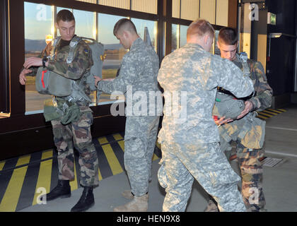 US Army Fallschirmjäger Assist französische Fallschirmjäger bereiten ihre Fallschirme vor Durchführung eine zerstreute Betrieb Dez. 17.  Die Operation, die von 5. Quartiermeister-Abteilung 21. Theater Sustainment Command (Airborne) koordiniert wurde, wurde als Teil des internationalen springen Woche durchgeführt, in denen Fallschirmjäger aus den USA, Deutschland, Frankreich, Spanien, den Niederlanden und Estland in der Luft zusammen in dem Bemühen, über Beziehungen und Interoperabilität zu bauen Operationen.  (Foto von Staff Sgt Warren W. Wright Jr., 21. TSC Public Affairs) Partnernationen beitreten U.S. für internationale Sprung Stockfoto