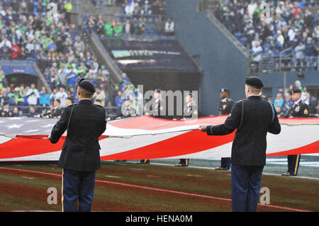 Soldaten der 4. Stryker Brigade der 2. Infanterie-Division, durchführen Farben-Schutz und Flagge Präsentation während der Seattle Seahawks vs. Arizona Cardinals Pregame show im Jahrhundert-Link-Feld, hier, Dez. 22. (Foto: U.S. Army Staff Sgt Tiffany Monnett, 4-2 SBCT PAO) Pregame Color Guard 131222-A-TM848-002 Stockfoto