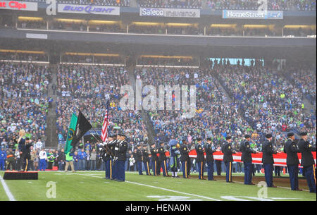 Soldaten der 4. Stryker Brigade der 2. Infanterie-Division, durchführen Farben-Schutz und Flagge Präsentation während der Seattle Seahawks vs. Arizona Cardinals Pregame show im Jahrhundert-Link-Feld, hier, Dez. 22. (Foto: U.S. Army Staff Sgt Tiffany Monnett, 4-2 SBCT PAO) Pregame Color Guard 131222-A-TM848-003 Stockfoto