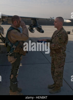 US Air Force major Sean "Hooligan" Holahan, eine f-16 Kampfjet pilot mit der 93. Expeditionary Jagdstaffel in Bagram Air Field, Afghanistan, grüßt eine amerikanische Flagge, statt von US Armee Generalmajor Matthew Price, der Versorgung-Offizier für die 401. Armee Feld Support Brigade, die am 13. Februar 2014 in Bagram, Afghanistan geflogen war. Die Flagge wurde im Gedenken an US-Army Spc. Jason Disney, ein Soldat mit dem 7. Transport-Bataillon, Fort Bragg, N.C. in Bagram Air Field, Afghanistan am 13. Februar 2002 verstorbenen geflogen. (Foto: US-Armee von Sgt. Jarred Woods, 1. Theater Sustainment Command) FLA Stockfoto