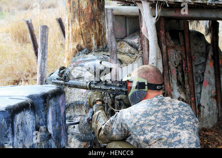 Ein Soldat zielt auf dem Paintball-Feld in Naval Station Guantanamo Bay 1. März 2014, während eine Kavallerie Sporn Fahrt reagieren um Bohrer zu kontaktieren. Die ganztägige Veranstaltung wurde in 10 Stationen im gesamten GTMO distanzierte segmentiert. (Armee Foto von Sgt Kenneth Tucceri/107 MPAD/JTF-GTMO Public Affairs) Tradition, Teamarbeit, die Kavallerie Sporn feierte ride 140301-A-ZI015-775 Stockfoto