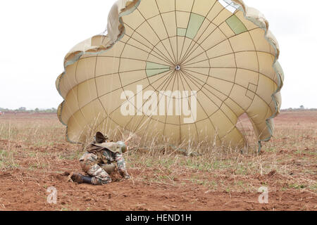 Ein Armee-Fallschirmjäger Kamerun kämpft gegen nach dem Sprung auf Koutaba Drop-Zone, während zentrale Accord 2014 in Koutaba, Kamerun, 17. März 2014 durch seinen Fallschirm gezogen wird. Zentralen Accord ist eine jährliche unter der Leitung von US-Armee Afrika Antenne Nachschub-Übung in Kamerun entworfen, die logistischen Kapazitäten der USA und kamerunischen zwingt.  (US Armee-Foto von Spc. Brady Pritchett/freigegeben) Ein Kamerun-Armee-Fallschirmjäger-Kämpfe seinen Fallschirm als He Ländereien 17. März 2014, während zentrale Accord 14 bei einem Drop zone in Koutaba, Kamerun 140317-A-GC728-024 Stockfoto