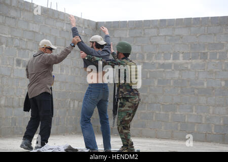 Ein Mitglied der Afghan National Security Force (ANSF) und einen Dolmetscher suchen ein Rollenspieler für versteckte Waffen oder Sprengstoff während taktische Mission Ausbildung am Kandahar Flugplatz, Provinz Kandahar, Afghanistan, 27. März 2014. ANSF Mitglieder wurden auf notwendigen Fähigkeiten, um eine führende Rolle im wirklichen Leben-Operationen in Afghanistan zu übernehmen. (US Armee-Foto von Pfc. Dacotah Lane / veröffentlicht) Einsatztaktischen Ausbildung in Kandahar Air Feld 140327-A-CR195-203 Stockfoto