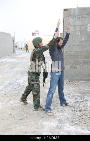 Ein Mitglied der afghanischen nationalen Sicherheit Force(ANSF) sucht eine Rolle Player belastendes Beweismaterial während taktische Mission Ausbildung am Kandahar Flugplatz, Provinz Kandahar, Afghanistan, 27. März 2014. ANSF Mitglieder wurden auf notwendigen Fähigkeiten, um eine führende Rolle im wirklichen Leben-Operationen in Afghanistan zu übernehmen. (US Armee-Foto von Pfc. Dacotah Lane / veröffentlicht) Ein Mitglied der Afghan National Security Forces (ANSF), links, sucht eine Rolle Player belastendes Beweismaterial während taktische Mission training 27. März 2014, Kandahar airfield, Afghanistan 140327-A-CR195-262 Stockfoto