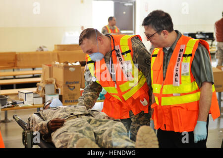 Eine US Armee-Krankenschwester aus Madigan Army Medical Center kommuniziert mit einem simulierten Patienten während der Operation Alaska Shield in der Nähe von McChord Flightline 1. April 2014. Diese Übung simuliert ein 9,2 Erdbeben ähnlich wie diejenige, die Anchorage, Alaska, 27. März 1964 schlug. Während des Prozesses war vom Laden der Patienten am Ort der Katastrophe zu entladen sie zum Zeitpunkt der Ausschiffung, Kommunikation mit dem Patienten notwendig. "Wenn ich nicht mit meinen Patienten zu kommunizieren, ihre Ergebnisse könnte schlimmer sein. Wenn ich ihnen nicht sagen, was vor sich geht, was Sie erwartet und wie wir versuchen, ihnen zu helfen, sind sie unterwegs Stockfoto