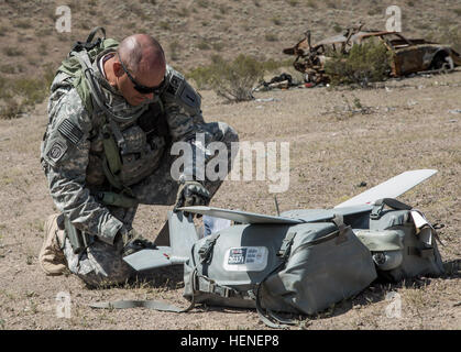 FORT IRWIN, Kalifornien - A US Armee-Soldat, 977th Military Police Company, 97. Military Police Battalion, 1st Infantry Division zugewiesen prüft die klingen und Flügel einen AeroVironment RQ-11 Raven vor, während einer Ausbildung im National Training Center, 19. April 2014 starten. Der Rabe ist eine kleine Hand gestartet remote - kontrollierten unbemannten (UAV) verwendet, um höhere Befehl eine Vogelperspektive auf einem bestimmten Gelände zeigen.  (Foto: US-Armee Sgt. Richard W. Jones Jr., Operations Group, National Training Center) National Training Center RQ-11 Raven Übung 140419-A-QU939-854 Stockfoto