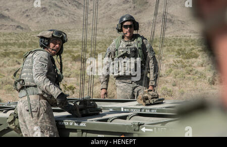 FORT IRWIN, Kalifornien - Soldaten der US Army, zugewiesene Alpha Company, 2. Bataillon, 1. Infanterie-Division, 34. Rüstung direkt Fellow Soldat während der Nachladen Verfahren auf einem m270 Multiple Launch Rocket System (MLRS) vor dem Start im National Training Center, 20. April 2014. Die MLRS ist ein Vielfaches gepanzerte, selbstfahrende, Raketenwerfer, die verwendet wird, um feindliche Ziele mehr als 175 Meilen entfernt zu engagieren und von feindlichen Zähler Feuer rasch an verschiedene Orte.  (Foto: US-Armee Sgt. Richard W. Jones Jr., Operations Group, National Training Center) M270 Multiple Launch Rocket System trai Stockfoto