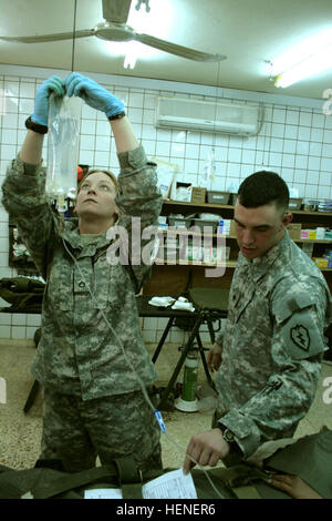 PFC.  Melanie Shelton, ein Henniker, NH, Native und Medic mit Firma C, 225. Brigade Support Battalion 2nd Stryker Brigade Combat Team "Krieger", 25. Infanterie-Division, Multi-National Division - Bagdad, beginnt sofort ärztliche Hilfe auf ein Sons of Iraq (Abna al Irak) Freiwillige, die in einer improvisierten Sprengkörpern Explosion, März 7 verletzt wurde. SPC. Ryan Maxfield, eine Howell, Michigan, Native und Medic zugewiesen Headquarters und Headquarters Company, 1. Bataillon, 27. Infanterie-Regiment "Wolfhounds," 2. SBCT 25. inf Div., MND-B unterstützt Shelton. (Foto der US-Armee / Brian Spc. Stockfoto