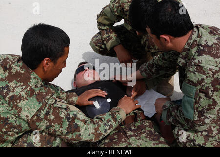 Soldaten der afghanischen Nationalarmee und der Militärpolizei üben am 22. April 2014 während einer Kampfklasse auf dem Bagram Airfield in der Provinz Parwan, Afghanistan, das Anbringen von Brustsiegeln auf Verletzte. Stockfoto