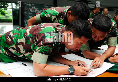 Soldaten der Tentara Nasional Indonesien Angkatan Darat (TNI-AD) indonesische Armee Punkte auf einer Karte von Indonesien während der Hawaii Army National Guard State Partnership Program Non-Commissioned Offizier Subject Matter Expert-Exchange zeichnen lernen bestimmen Rasterkoordinaten während einer Kartenlesen Block des Unterrichts 24. April 2014. (Foto: US-Armee Sgt. 1. Klasse Theresa Gualdarama) Hawaii Armee Gardisten Austausch mehr als militärisches Fachwissen mit indonesischen Armee Unteroffiziere 140424-A-PI315-190 Stockfoto