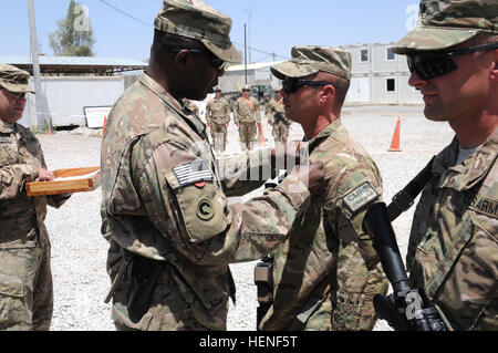 Generalmajor Darrell K. Williams, Kommandant, 1. Theater Sustainment Command, präsentiert das Combat Action Abzeichen, um Native Tebbetts, Mo., Sgt Chad Sheehan, eine schwere Ausrüstung Betreiber für das Fort Leonard Holz, Mo.-955th Ingenieur Unternehmen, angebracht zu den Little Rock, Arkansas-basierte 489th Engineer Battalion, während einer Preisverleihung am 26. April um Kandahar Airfield, Afghanistan. Truppen mit der 955th führen in Afghanistan im Rahmen von Fort Bragg, N.C.-basierte 82. Sustainment Brigade-US Befehl Materiel Recovery Zentralelement Dekonstruktion. (Foto: US-Armee Sgt. 1. Klasse Jon Cupp, 82. SB-C Stockfoto