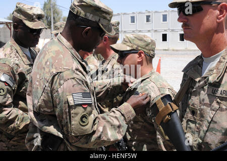 Generalmajor Darrell K. Williams, Kommandant, 1. Theater Sustainment Command, präsentiert der Combat Action Abzeichen, Victoria, Texas geboren, Spc. Dominic Galindo, eine schwere Ausrüstung Betreiber für das Fort Leonard Holz, Mo.-955th Ingenieur Unternehmen, angebracht zu den Little Rock, Arkansas-basierte 489th Engineer Battalion, während einer Preisverleihung am 26. April um Kandahar Airfield, Afghanistan. Truppen mit der 955th führen in Afghanistan im Rahmen von Fort Bragg, N.C.-basierte 82. Sustainment Brigade-US Befehl Materiel Recovery Zentralelement Dekonstruktion. (Foto: US-Armee Sgt. 1. Klasse Jon Cupp, 82. Stockfoto