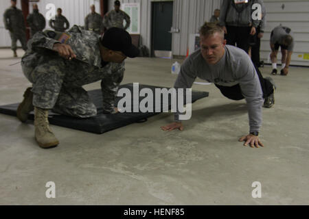 US Armee Sgt. Benjamin Mercer mit dem 688. Ingenieur-Unternehmen führt Push-ups während einer Armee-körperliche Fitness-Test. Soldaten des Befehls 412. und 416th Theater Ingenieur startete den regional Finals für die besten Krieger Wettbewerb 2014 mit Fitnesstest vor Sonnenaufgang am Fort McCoy, Wisconsin, USA, April 28. Die Teilnehmer hatten auch mit den rauen saisonalen Wetterbedingungen von in der Nähe von eisigen Temperaturen, heftige Winde und Regen wehen zu kämpfen. (Foto: U.S. Army Armee Reserve Staff Sgt Scott Griffin, 207. Public Affairs Abteilung/freigegeben) Armee Krieger beginnen Wettbewerb mit zermürbenden Körperbehinderten Stockfoto