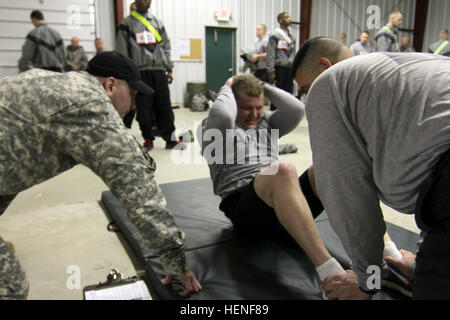 SPC. Tommy Jones mit der US Army Reserve 401. Ingenieur-Unternehmen beteiligt sich an der Sit-up-Veranstaltung während einer Armee-körperliche Fitness-Test. Soldaten des Befehls 412. und 416th Theater Ingenieur startete den regional Finals für die besten Krieger Wettbewerb 2014 mit Fitnesstest vor Sonnenaufgang am Fort McCoy, Wisconsin, USA, April 28. Die Teilnehmer hatten auch mit den rauen saisonalen Wetterbedingungen von in der Nähe von eisigen Temperaturen, heftige Winde und Regen wehen zu kämpfen. (Foto: U.S. Army Armee Reserve Staff Sgt Scott Griffin, 207. öffentlichen Angelegenheiten Abteilung/freigegeben) Armee Krieger beginnen wieder Stockfoto