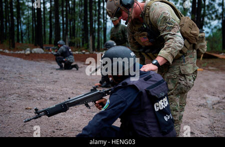 Ein Green Beret schaut in die Gewehr-Kammer von einem TIGRES-Kommando bei umgrenzenden Overwatch Übungen mit scharfer Munition während des Trainings mit Green Berets aus der 7th Special Forces Group (Airborne) und Junglas aus der kolumbianische Nationalpolizei in Tegucigalpa, Honduras, 8. Mai 2014. Die TIGRES werden die honduranische Regierung Kraft der Wahl Geschäfte um hochwertige Narcotraffiking Ziele und kriminelle Führung zu erfassen. US Green Berets, kolumbianische Junglas Zug honduranischen TIGRES 140508-A-YI554-327 Stockfoto