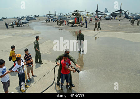 Philippinische Kinder stellen sich an, um einen Feuerschlauch mit Unterstützung der US Air Force Crash Fire Rescue während einer statischen Flugzeugpräsentation auf der Clark Air Base am 10. Mai 2014 zu benutzen, um Balikatan 2014 zu unterstützen. Die Veranstaltung erlaubte Familien und Gemeindemitgliedern, philippinische und US-amerikanische Flugzeuge zu sehen. Stockfoto
