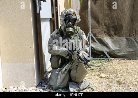 Eines österreichischen Soldaten der 2. Kompanie, 25. Infanterie-Bataillon, 7. Infanterie-Brigade sorgt für Sicherheit beim Tragen einer Gasmaske und chemische Anzug während der Übung kombiniert zu beheben II bei der Joint Multinational Readiness Center in Hohenfels, Deutschland, 25. Mai 2014.  Kombinierte Lösung II ist eine multinationale entschlossenes Handeln Umwelt Übung in Hohenfels und Grafenwöhr Schulungsräume, die mehr als 4.000 Teilnehmer aus 15 Partnernationen beinhaltet das Joint Multinational Training Command auftreten.  Die Absicht der Übung ist, zu trainieren und Vorbereiten einer US multinationale Brigade führte zu ich Stockfoto