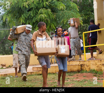 Zwei einheimische Jugendliche zusammen mit Soldaten der US Army Reserve, bewegen Boxen Bücher der Fidelina Feliz-Matos öffentlichen (Kindergarten bis zur achten Klasse) Grundschule in La Guazara, Dominikanische Republik, als Teil von Beyond the Horizon 2014, eine dreimonatige multinationale humanitäre Übung, 8. Juni 2014. Ein neues Gebäude wurde vor kurzem in der Schule von Piloten der Air National Guard 200. 210. RED HORSE (schnelle Ingenieur bereitgestellt schwere operative Reparatur Squadron Ingenieure) Staffeln und aus Ohio und New Mexico gebaut. (Foto: US-Armee Sgt. 1. Klasse Steve Segin, 207. Public Affairs-Detachme Stockfoto