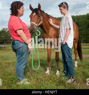 Donna Otabachian, executive Director der Star Heilung mit Pferde Ranch, führt eine Pferdetherapie-Sitzung mit Roger Flores-Hoops, 14, 17. Juni 2014 sekundäre PTBS leidet. SHWH, befindet sich auf der weitläufigen Parrie Haynes Ranch südlich von Fort Hood, ist eine Organisation zur Heilung alles, die Trauma, PTSD und sekundären PTSD erfahren haben. Sekundäre PTBS ist vor allem von den Kindern von Service-Mitglieder, die PTBS, haben gelitten, da sie traumatisiert werden können, durch Veränderungen in ihrer Eltern Persönlichkeiten und die Konflikte, die aus diesen Änderungen ergeben. SHWH hat dazu beigetragen, viele dieser Kinder Stockfoto