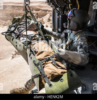 SPC. Giles Dunlop, Crewchief, wirft eine simulierte Casulaty in seinem Flugzeug von Hebezeug während ein Personal Recovery Übung zwischen einem UH-60 Black Hawk am 19. Juni 2014, in Kuwait von Unternehmen C, 1. Bataillon, 214th Air Ambulance, 42. Combat Aviation Brigade (CAB) und eine kuwaitische Luftwaffe SA 330 Puma Hubschrauber geflogen. 42. CAB und kuwaitischen Streitkräfte führen regelmäßig gemeinsame Partnerschaften ein, um ihre Fähigkeit zur Reaktion auf Notfälle zu verbessern. Die 42. CAB, New York Army National Guard wird nach Kuwait zur Unterstützung der Operation Enduring Freedom eingesetzt. (New York Army National Guard Foto von Sgt. Harl Stockfoto