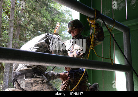 Cadet Breenen Doughty ist von Todd Beamer High School, in der Junior Reserve Officer Training Corps, angeschlossen an einen Sicherheitsgurt durch Staff Sgt William Borego, mit der Washington Army National Guard Recruiting und Retention Bataillon vor dem Abseilen aus der zweiten Geschichte eines Training-Turm während einer Woche lange JROTC Führung Camp gehostet von der Washington National Guard, vom 23.-27. Juni , 2014 bei Joint Base Lewis-McChord, Wash Kadetten absolvieren drei Abseilstellen während des JROTC Führung Camps, beginnend mit einer 45 Grad Steigung vor dem Abseilen aus der zweiten und dritten Geschichte von einem tr Stockfoto